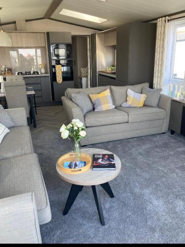 a living room with a couch and a table at Bailey Lodge in Padstow