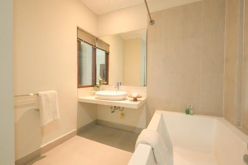 uma casa de banho com uma banheira e um lavatório e uma banheira em Artini Bisma Ubud Hotel em Ubud