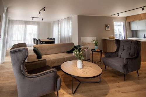 a living room with a couch and chairs and a table at Sleep Inn Medienhafen Suites in Düsseldorf