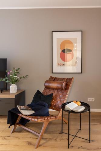a living room with a leather chair and a table at Sleep Inn Medienhafen Suites in Düsseldorf