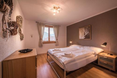 um quarto com uma cama grande e uma janela em Breithorn Apartment, Eiger North Face View em Grindelwald