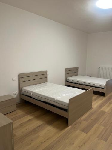 Duas camas num quarto com pisos em madeira em La casa dello zio em Vasto