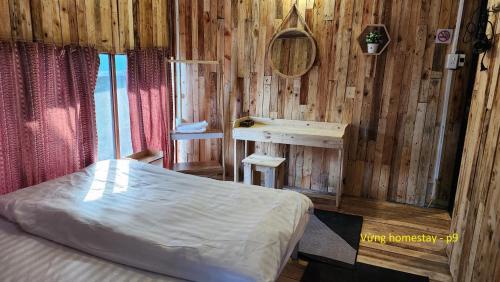 a bedroom with a bed and a wooden wall at Vừng Homestay - Taxua in Bắc Yên