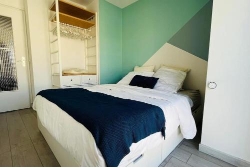 - une chambre avec un grand lit et un mur bleu dans l'établissement Rooftop Garden, à Antibes