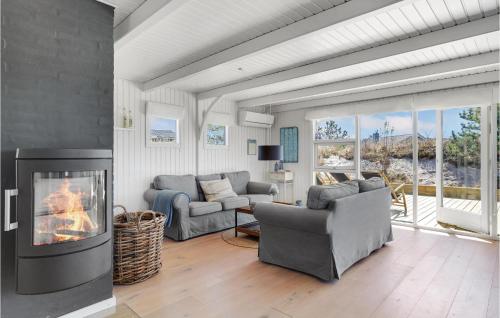 a living room with a fireplace and a couch and chairs at 3 Bedroom Cozy Home In Ringkøbing in Ringkøbing