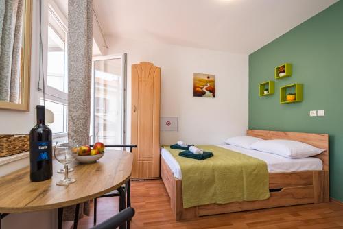 a bedroom with a bed and a table with a bowl of fruit at Studio and Rooms Zadar City Wall in Zadar