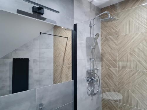 a shower with a glass door in a bathroom at Hotel Savana in Kłaj