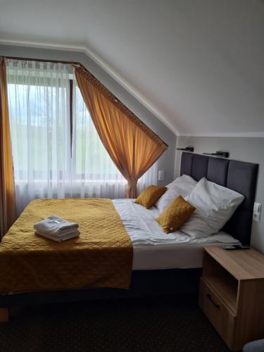 a bedroom with a large bed with a window at Hotel Savana in Kłaj