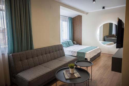 - un salon avec un canapé et un lit dans l'établissement BEST APARTMENTS, à Bitola