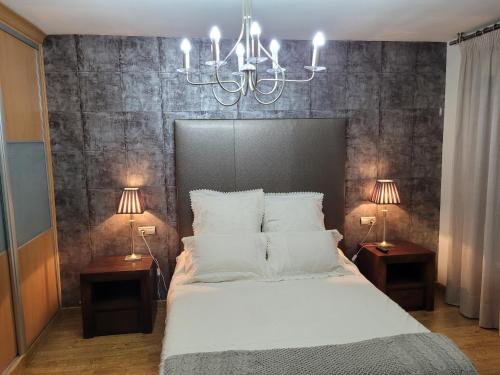 a bedroom with a large white bed with two lamps at Privada Confort Granada in Granada