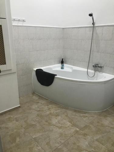 a white bath tub in a bathroom with a shower at Szenes-House Apartman in Budapest