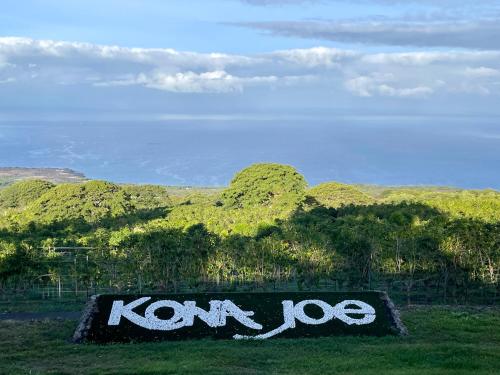 a sign that says kon dog in the grass at Haukea at Kona Joe Coffee Farm in Kealakekua