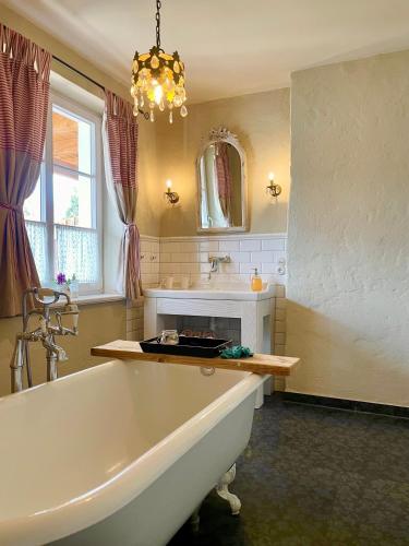 a bathroom with a tub and a sink and a mirror at Weißt Du noch - Gästehäuser & Suiten in Kühlungsborn