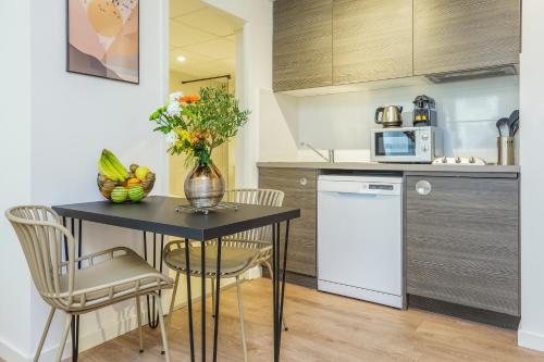 kuchnia ze stołem z wazonem kwiatów w obiekcie Aparthotel Adagio Montpellier Centre Comedie w Montpellier