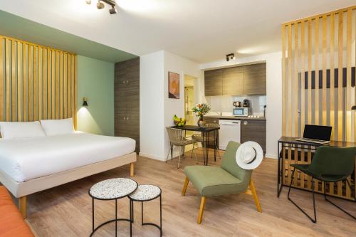 a hotel room with a bed and a kitchen at Aparthotel Adagio Montpellier Centre Comedie in Montpellier