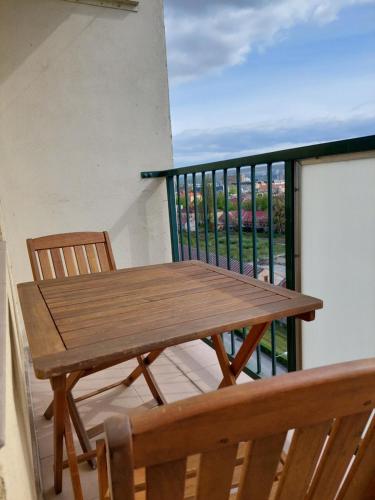 a wooden table and chairs on a balcony at Moderny byt, 300 m do centra mesta in Košice