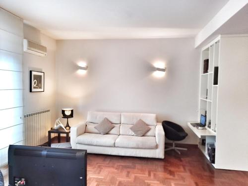 sala de estar con sofá blanco y TV en Lovely Modern Apartment, en Florencia