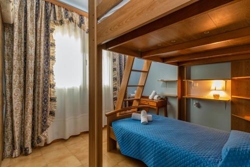 Un dormitorio con una cama azul y una escalera en Casa d' Acqua, en Archangelos