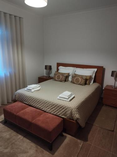 a bedroom with a large bed with a red ottoman at Moradia gémea 2 em Herdade Santa Marta in Zebreira