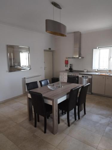 a kitchen with a wooden table and chairs at Moradia gémea 2 em Herdade Santa Marta in Zebreira