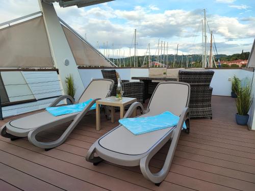 a deck with chairs and a table on a boat at SEA LUX FLOATING HOUSE AJDA Portorose in Portorož