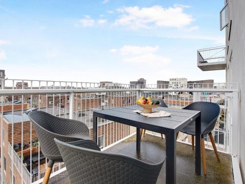 a table and chairs on a balcony with a view at Sanders Arena - Chic Three-Bedroom Apartment Close to Metro Station in Copenhagen