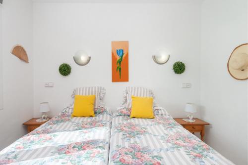 2 Betten in einem Schlafzimmer mit gelben Kissen in der Unterkunft Apartamento Silver in Port d'Alcúdia