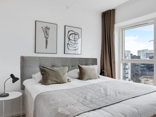 Un dormitorio con una cama grande y una ventana en Sanders Arena - Chic Three-Bedroom Apartment Close to Metro Station, en Copenhague