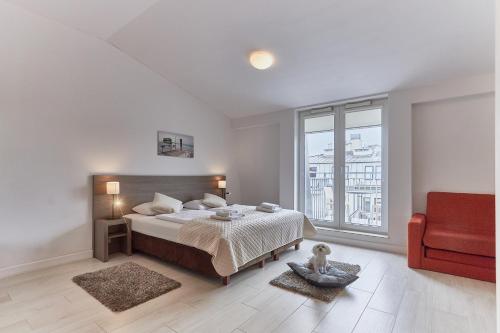 MariSol في سفينويتشي: غرفة نوم بيضاء بسرير وكرسي احمر