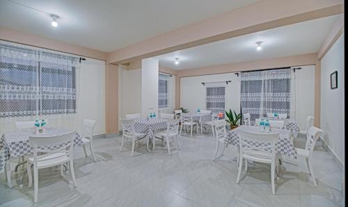 a dining room with white tables and white chairs at Treebo Staying Center in Shillong