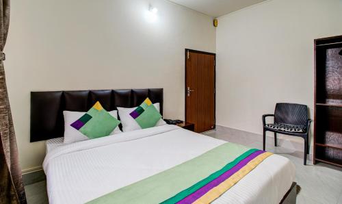a bedroom with a large white bed with colorful pillows at Treebo Staying Center in Shillong