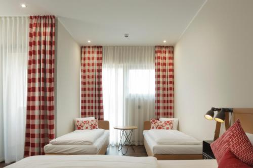 a bedroom with two beds and a window at Mjus Resort & Thermal Park in Körmend