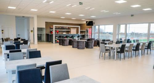 une cafétéria avec des tables et des chaises dans un bâtiment dans l'établissement KIRÁLY PARK HOTEL, à Szombathely