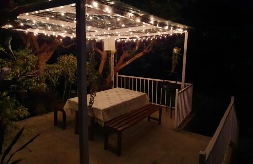 a pergola with lights on a deck at night at Aaravi Garden Homestay in Kalimpong