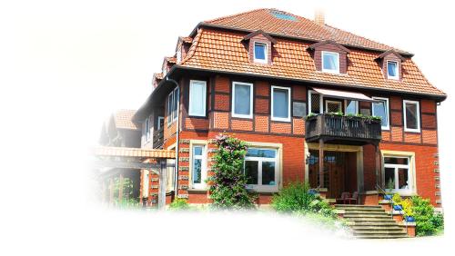 a large red brick house with a balcony at Hof Klostermann in Hessisch Oldendorf