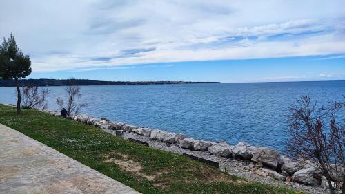 a large body of water with a rock wall at SEA LUX FLOATING HOUSE AJDA Portorose in Portorož