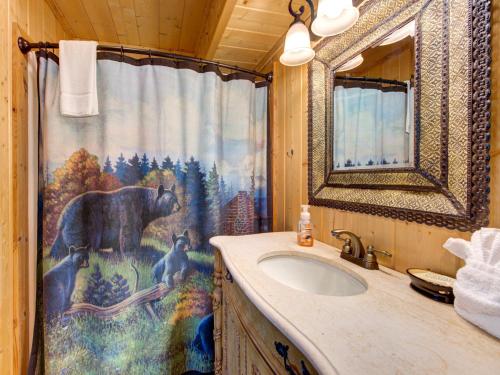 a bathroom with a bear shower curtain and a sink at Edens View in Gatlinburg