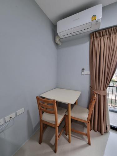 a table and chair in a room with a window at Tiara Place in Bangkok
