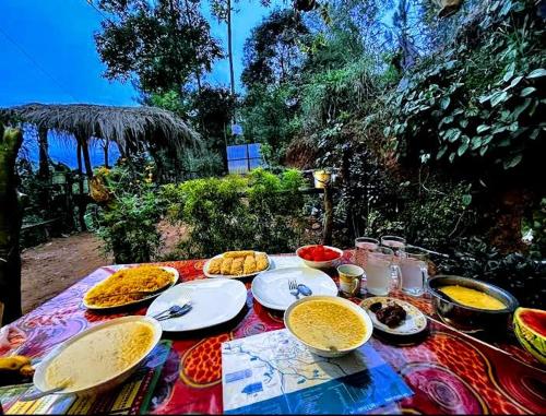 einen Tisch mit Teller und Schüsseln mit Essen drauf in der Unterkunft Green Jungle " Cool view" in Ella