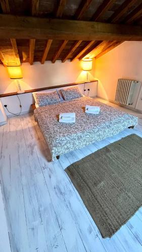 a bedroom with a bed with two pillows and a rug at Il grillo in Rosignano Marittimo