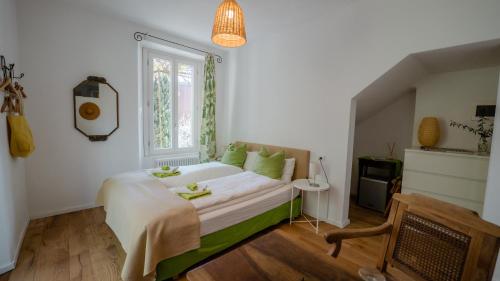 Un dormitorio con una cama con almohadas verdes y una ventana en Villa Monte Bianco, en Mandello del Lario