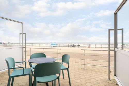 a table and chairs on a balcony overlooking the beach at C-Hotels Excelsior in Middelkerke
