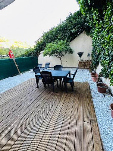 una terraza de madera con mesa y sillas. en Appartements avec jardin en Niza