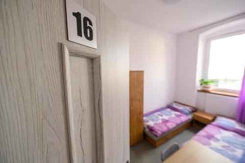 una habitación con una cama y un número en la pared en MRU Rooms, en Racibórz