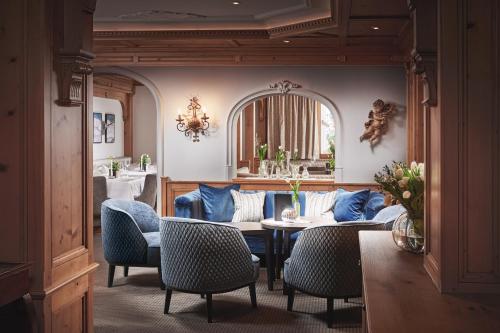 a living room with a couch and a table and chairs at Hotel Auenhof in Lech am Arlberg