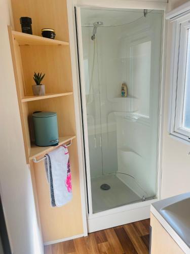 a shower with a glass door in a bathroom at Mobil home 8 personnes camping L'Elysée Vagues Océanes in Le Grau-du-Roi