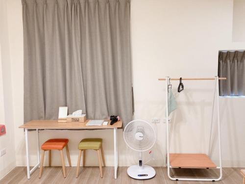 un bureau avec trois chaises et une table avec un ventilateur dans l'établissement 聽故事台南民宿 有貓的民宿, à Tainan