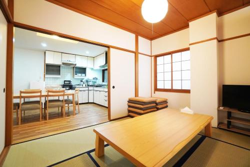 a living room with a table and a kitchen at Kagetsu 2nd Building in Osaka
