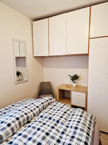 1 Schlafzimmer mit 2 Betten, einem Schreibtisch und weißen Schränken in der Unterkunft Ferienhaus Kranichnest in Barth