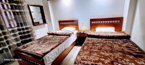 a bedroom with two beds and a mirror at Moon fourteen2 in Luxor